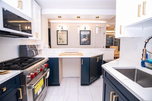 kitchen with white cabinetry, sink, hanging light fixtures, blue cabinets, and appliances with stainless steel finishes