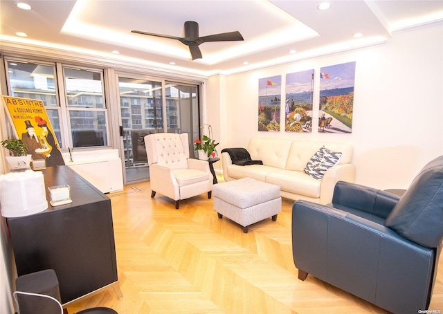 living room featuring parquet flooring, a tray ceiling, and ceiling fan