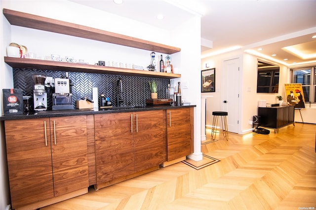 bar featuring decorative backsplash, light parquet floors, and sink