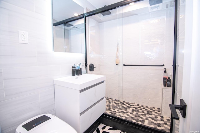 bathroom featuring an enclosed shower, vanity, and tile walls