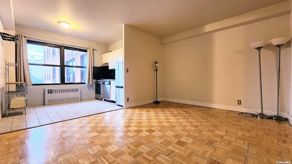 99-52 66th Rd Unit 5P, Rego Park, NY 11374 - unfurnished living room with light parquet floors and radiator