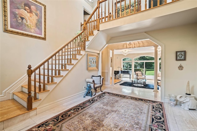 entrance foyer featuring tile patterned flooring, a high ceiling, and a chandelier