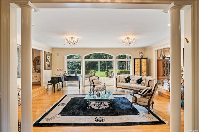 living room featuring ornate columns, ornamental molding, and hardwood / wood-style flooring