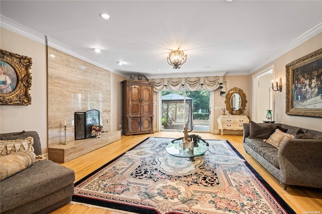 living room with an inviting chandelier, ornamental molding, and light hardwood / wood-style flooring