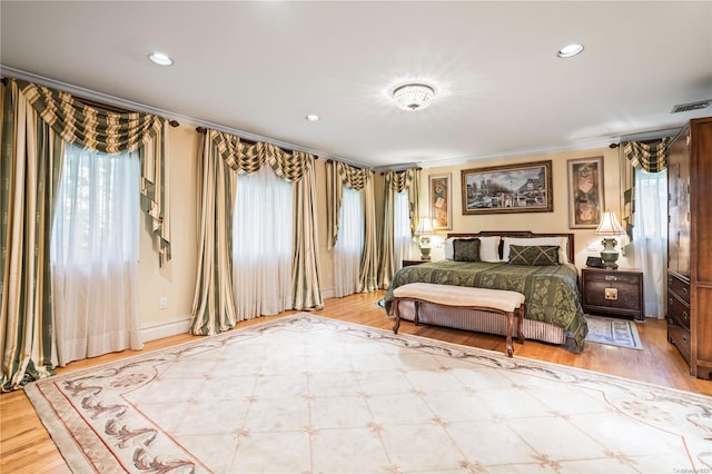 bedroom featuring ornamental molding and hardwood / wood-style flooring