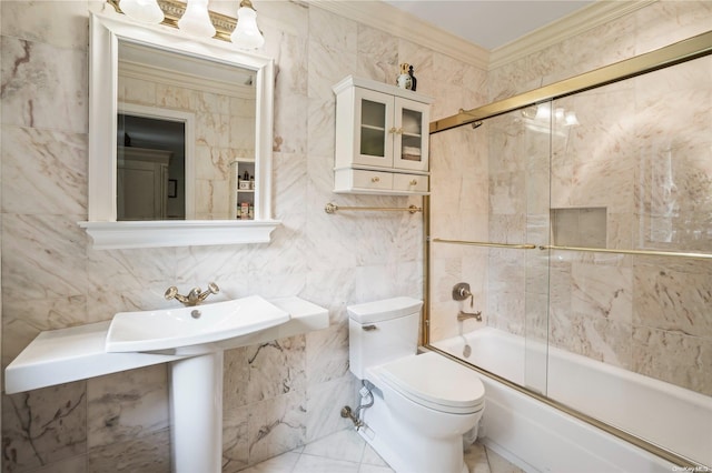 bathroom with tile walls, crown molding, and bath / shower combo with glass door