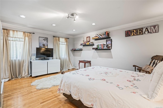 bedroom featuring multiple windows, crown molding, and hardwood / wood-style floors