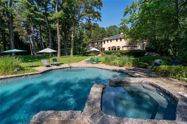 view of swimming pool with a lawn and an in ground hot tub