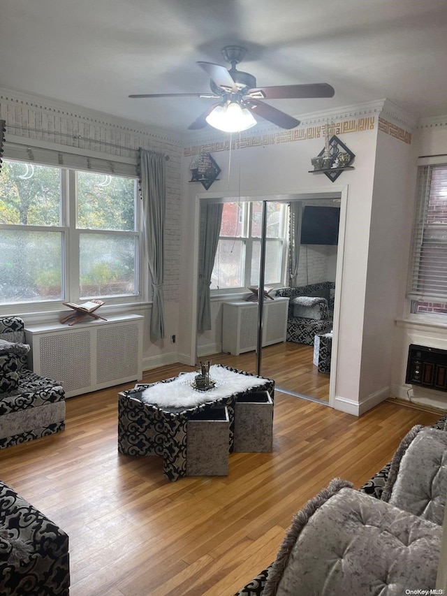 living room featuring radiator heating unit, ceiling fan, and wood-type flooring