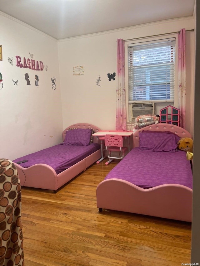 bedroom featuring hardwood / wood-style floors, cooling unit, and crown molding