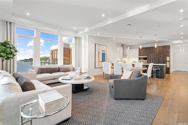 living room with hardwood / wood-style flooring and a water view