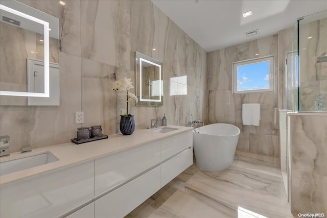 bathroom featuring vanity, tile walls, and a tub to relax in