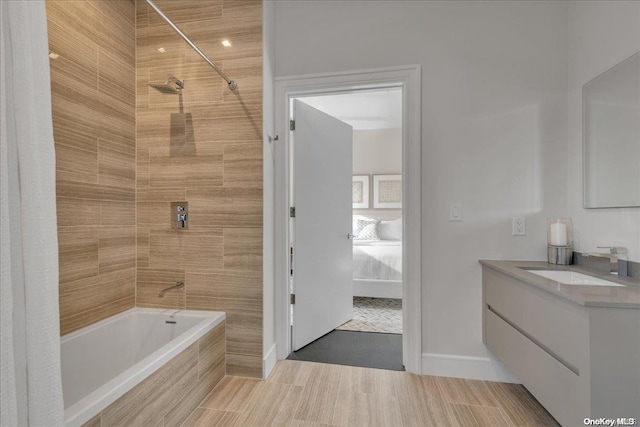 bathroom featuring tiled shower / bath and vanity