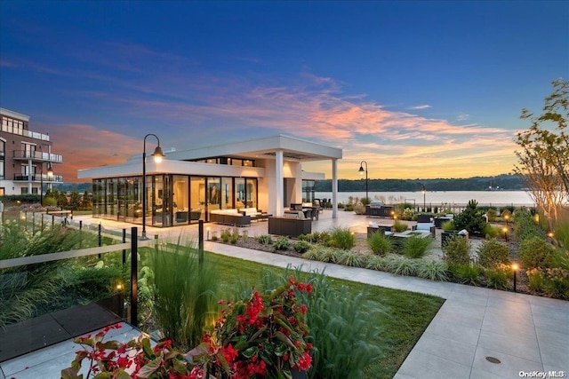 exterior space with an outdoor living space, a patio, and a water view