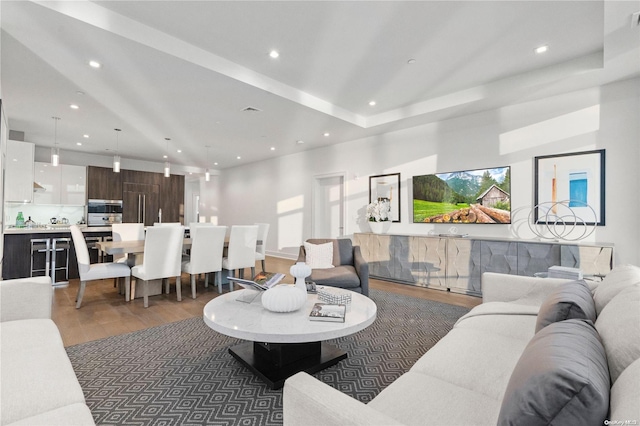 living room with dark hardwood / wood-style flooring and a raised ceiling