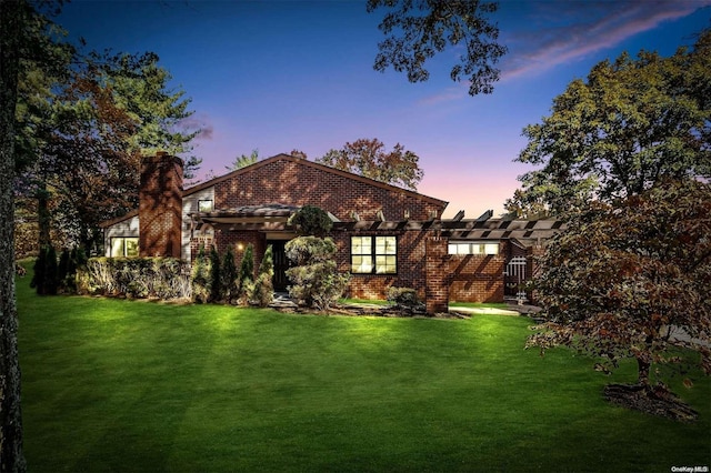 view of front of house with a lawn and a pergola