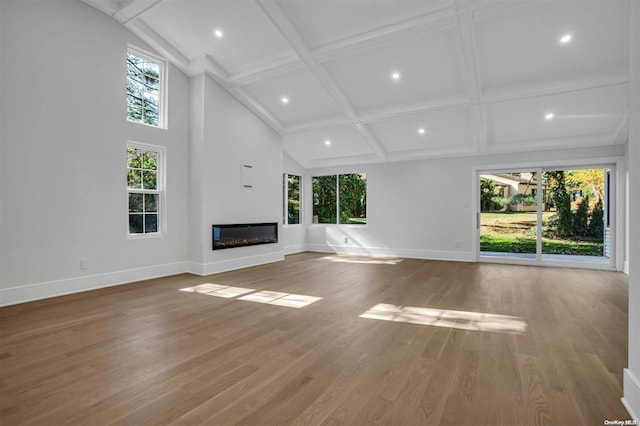 unfurnished living room featuring hardwood / wood-style flooring, plenty of natural light, and coffered ceiling