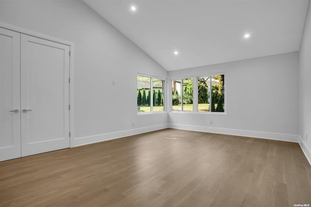 empty room featuring light hardwood / wood-style flooring and high vaulted ceiling