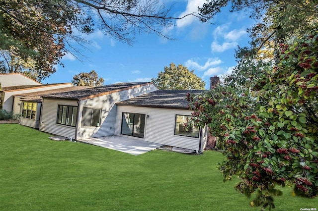 back of house with a patio area and a yard