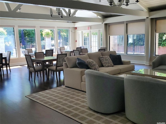 living room with hardwood / wood-style flooring, a notable chandelier, a healthy amount of sunlight, and lofted ceiling with beams