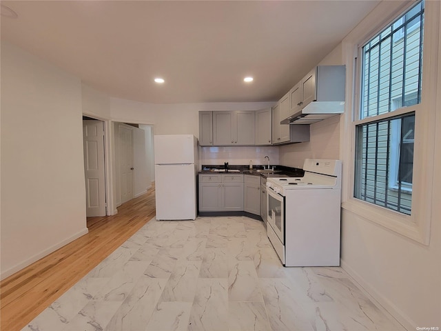 kitchen with gray cabinets, white appliances, marble finish floor, and baseboards