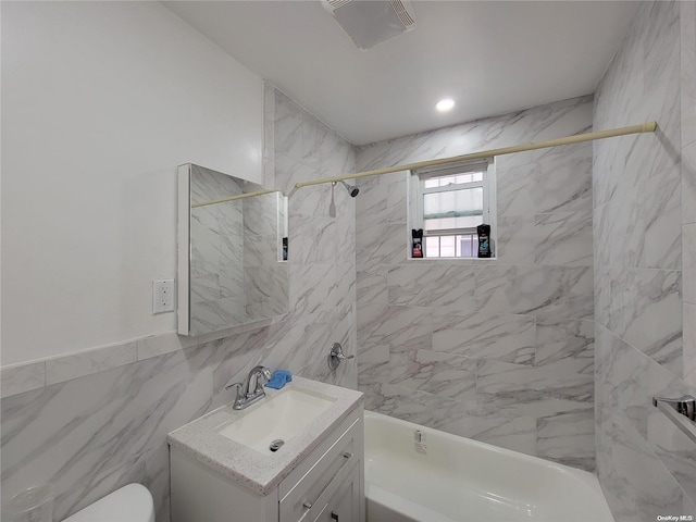 full bath featuring vanity, visible vents, shower / washtub combination, tile walls, and toilet