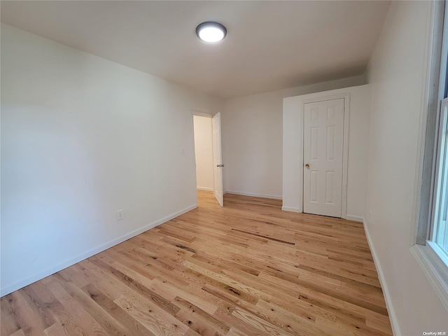 unfurnished room featuring light wood finished floors and baseboards