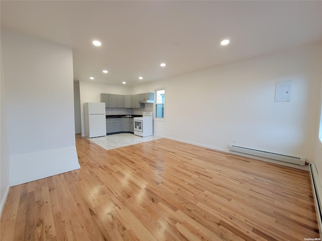 unfurnished living room with recessed lighting, a baseboard radiator, baseboards, and light wood finished floors