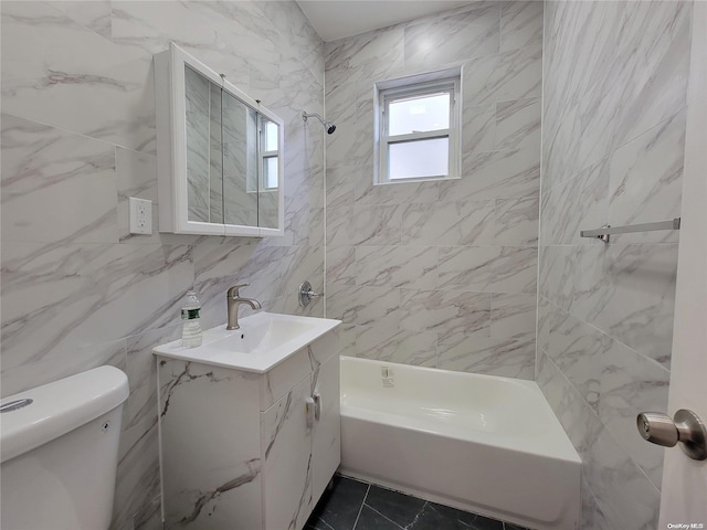 bathroom with tile walls, shower / washtub combination, toilet, and vanity