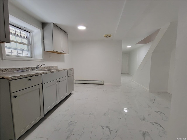 kitchen featuring a sink, marble finish floor, baseboards, and a baseboard radiator