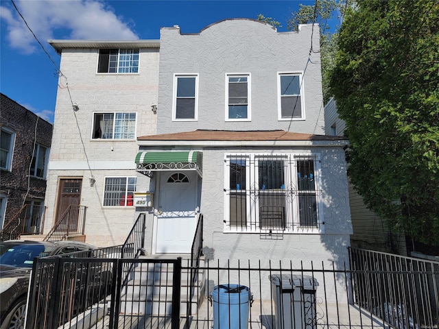 view of front of home with a fenced front yard and stucco siding