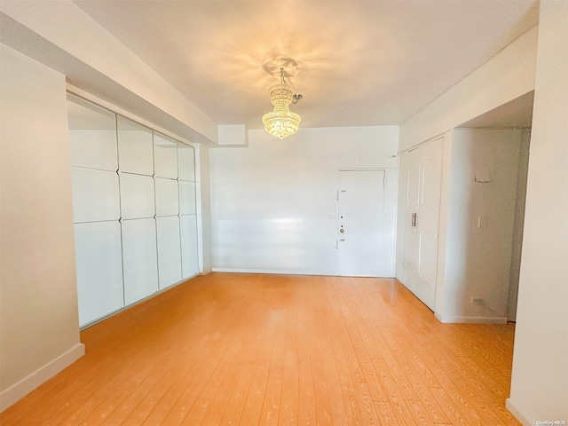 empty room featuring light hardwood / wood-style floors and an inviting chandelier