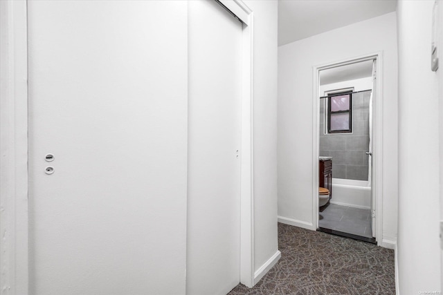 hall featuring dark tile patterned flooring