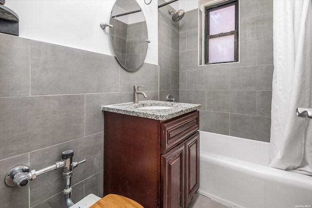 bathroom featuring tile walls, vanity, and shower / tub combo