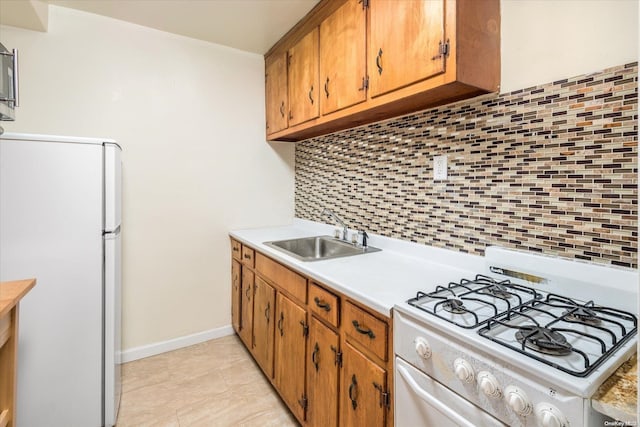 kitchen featuring white appliances, tasteful backsplash, and sink