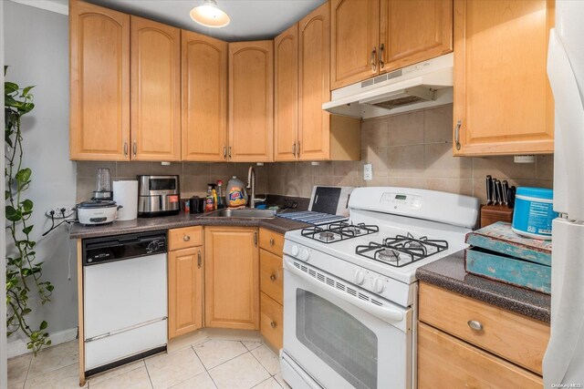 kitchen featuring white appliances, sink, light tile patterned floors, and tasteful backsplash