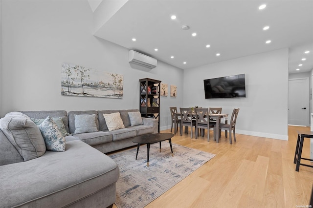 living room featuring light hardwood / wood-style flooring and a wall unit AC