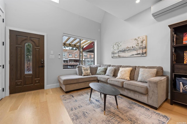 living room with a wall mounted AC, light hardwood / wood-style flooring, and vaulted ceiling