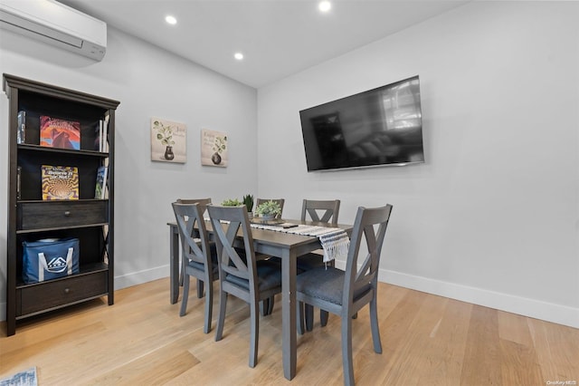 dining space featuring light hardwood / wood-style flooring and a wall unit AC