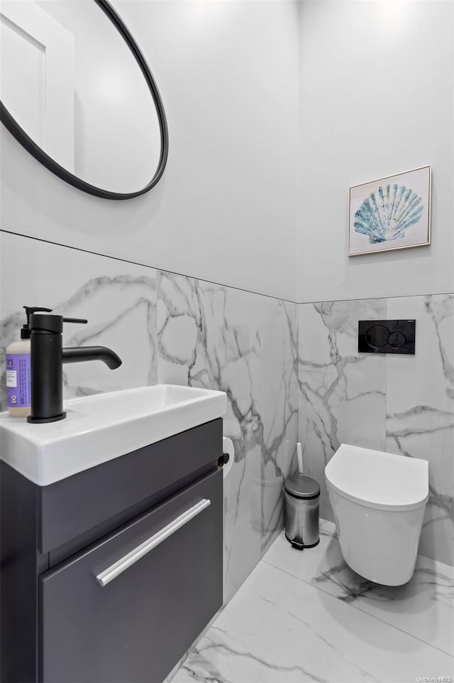 bathroom featuring vanity, tile walls, and toilet