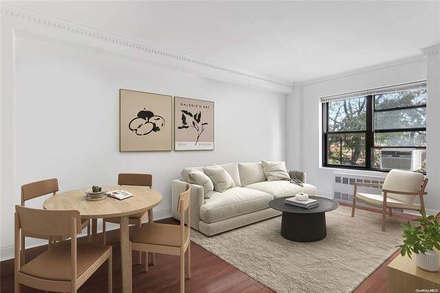 living room with radiator heating unit, crown molding, cooling unit, and dark wood-type flooring