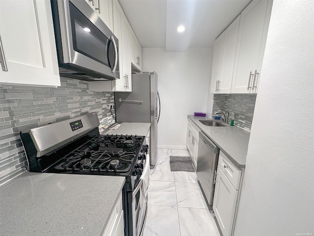 kitchen featuring white cabinets, decorative backsplash, stainless steel appliances, and sink