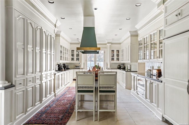 kitchen with a center island, island exhaust hood, crown molding, and tasteful backsplash