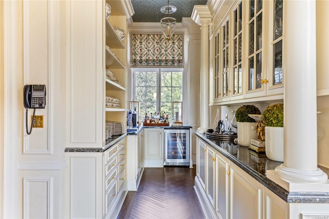 bar featuring ornate columns, ornamental molding, a textured ceiling, dark parquet floors, and wine cooler