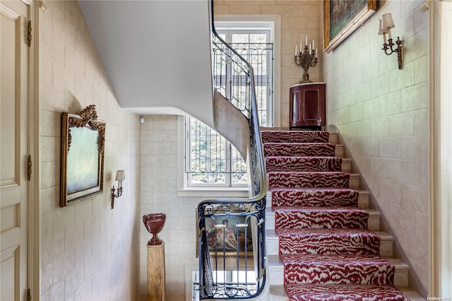 stairway featuring tile walls and vaulted ceiling