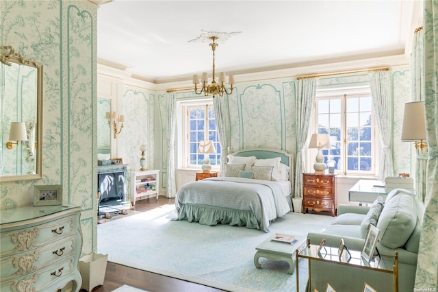 bedroom featuring hardwood / wood-style flooring, crown molding, and a chandelier