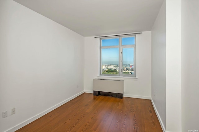 unfurnished room featuring wood-type flooring and radiator