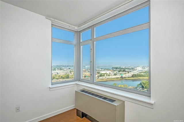 interior space featuring radiator, hardwood / wood-style floors, and a water view