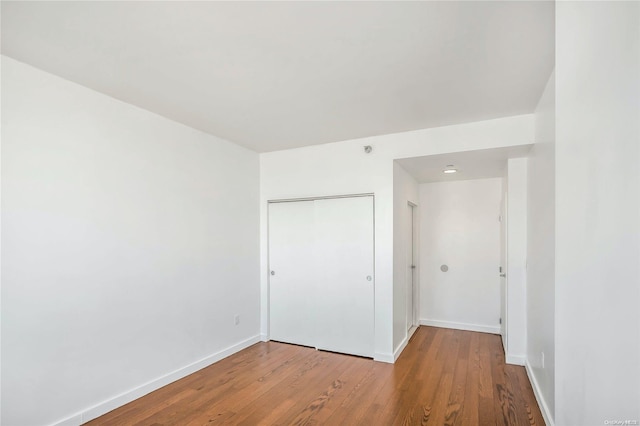 unfurnished bedroom featuring a closet and hardwood / wood-style flooring