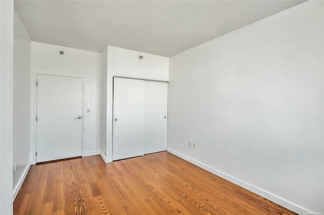 unfurnished bedroom with a closet and light hardwood / wood-style flooring